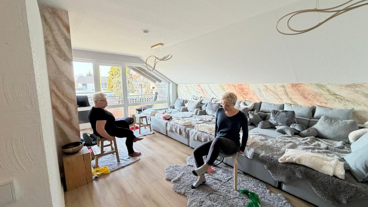 Stuhl Yoga im Klangraum: zwei Teilnehmerinnen sitzen auf Hockern vor der Liegelandschaft